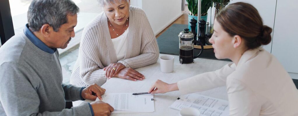 A man and woman review paperwork with an attorney