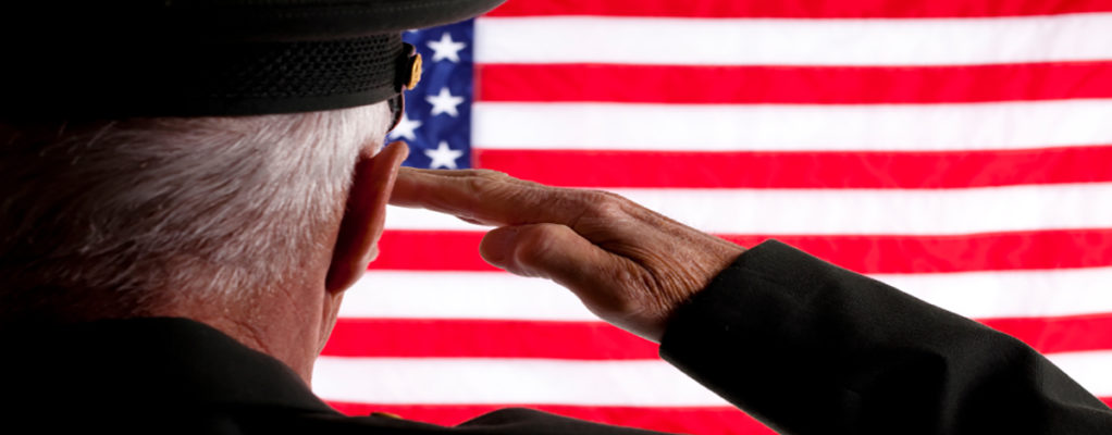 Veteran saluting American flag