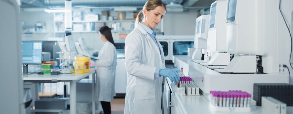 A lab technician examines multiple sets of vials