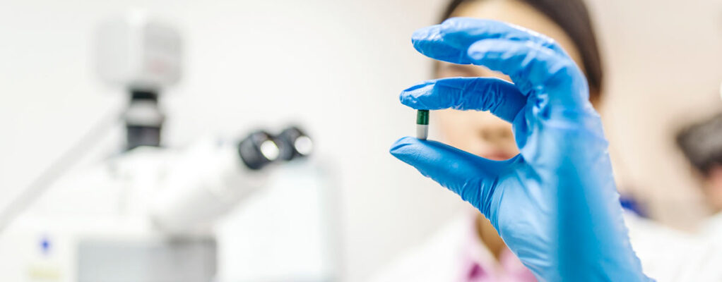 A scientist holding a pill