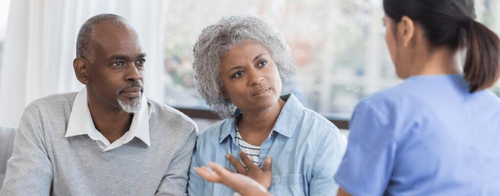 Man and woman speaking with female doctor.